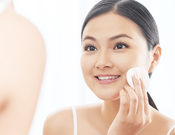 woman touching her face with white cotton
