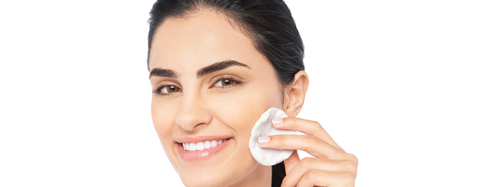 woman cleaning her face with cotton