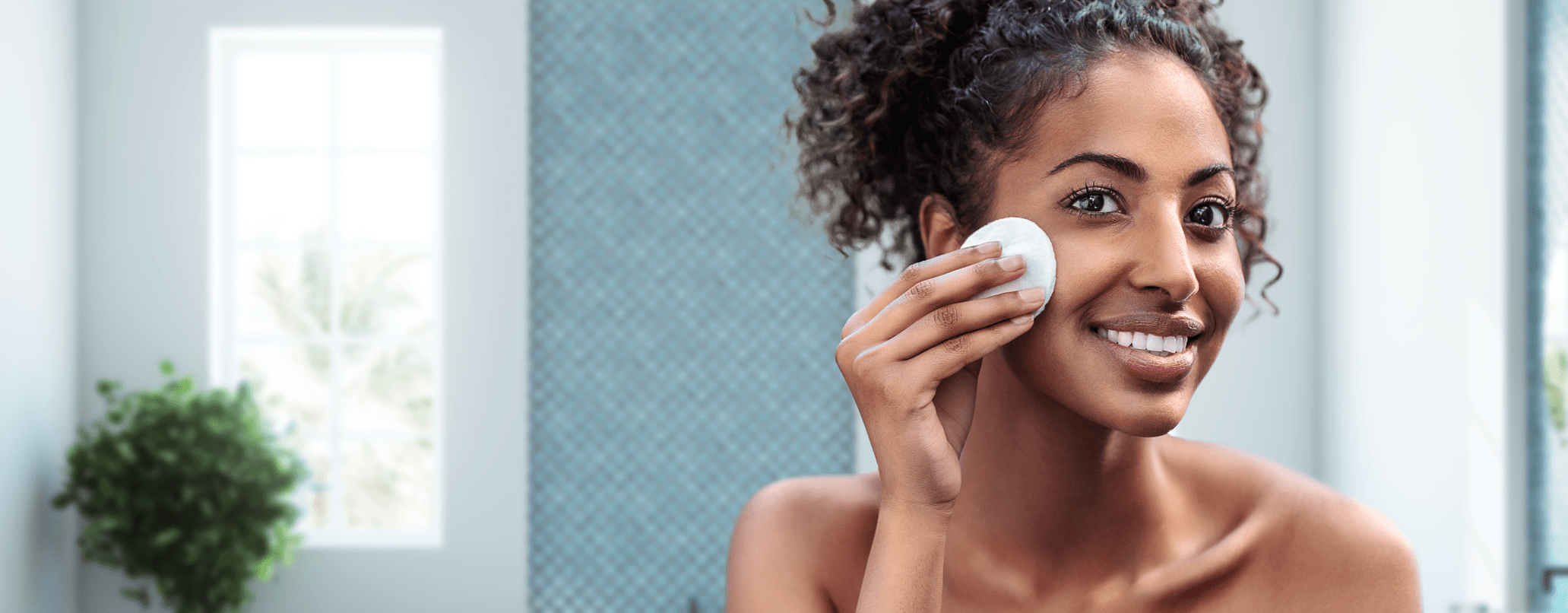 Woman cleaning her face with micellar water and face scrub