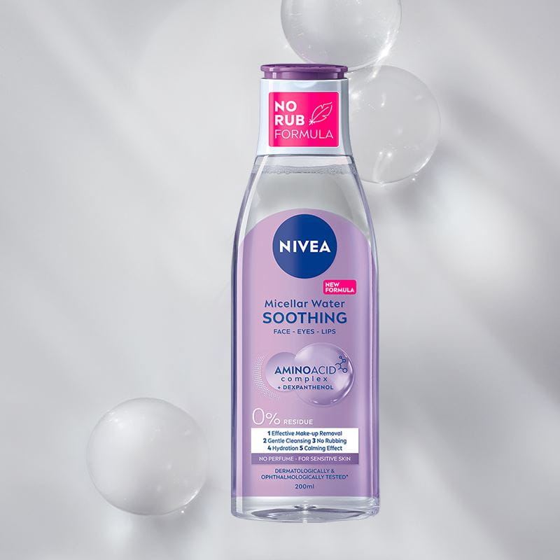 A bottle of NIVEA Micellar Water for Normal Skin lays on a blue bubble textured background.