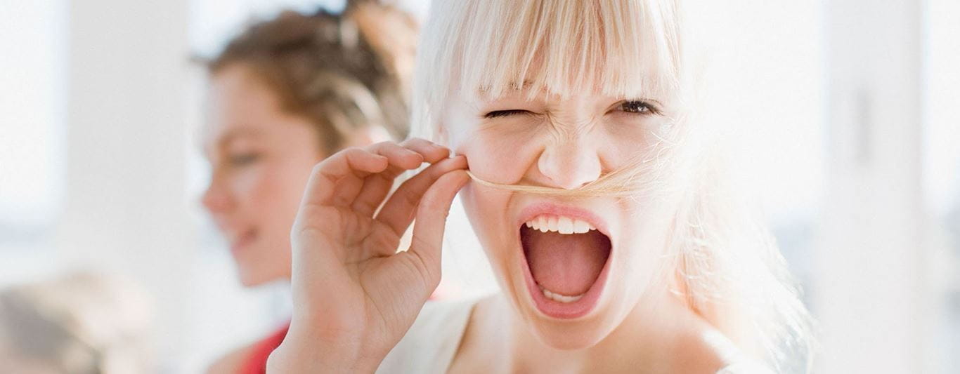 Mulher a brincar com cabelo a fazer de bigode