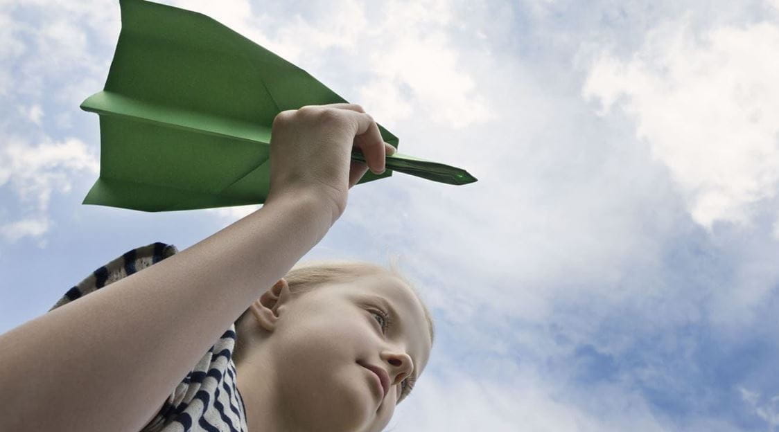 criança com avião de papel